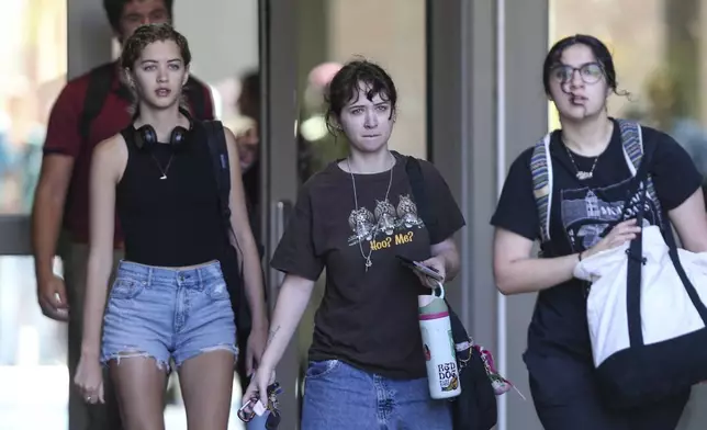Students leave after retrieving their personal items from the Florida State Student Union, Tallahassee, Fla., Friday, April 18, 2025. (AP Photo/Gary McCullough)