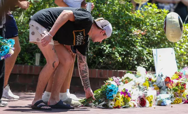 A student places flowers near the Florida State Student Union building, Tallahassee, Fla., Friday, April 18, 2025. (AP Photo/Gary McCullough)