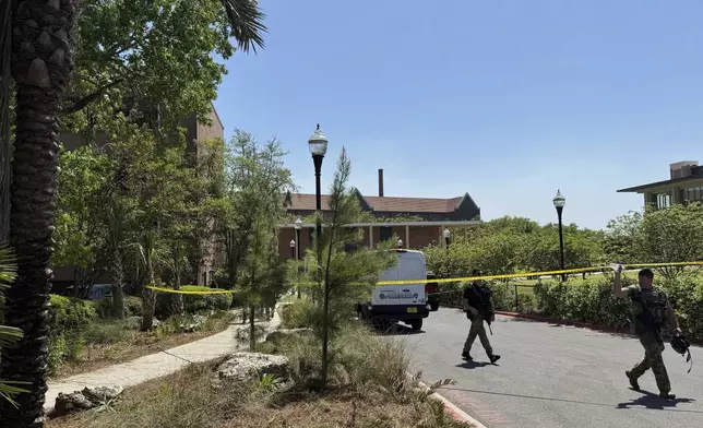Dozens of patrol vehicles, including a forensics van, are stationed outside of Florida State University’s student union building, the scene of a shooting, Thursday, April 17, 2025, in Tallahassee, Fla. (AP Photo/Kate Payne)
