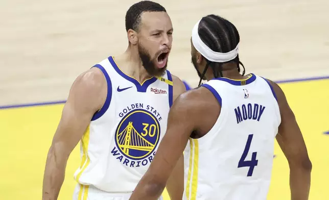 Golden State Warriors' Stephen Curry (30) celebrates a dunk by Moses Moody (4) against the Memphis Grizzlies during the first half of an NBA play-in tournament basketball game in San Francisco, Tuesday, April 15, 2025. (Scott Strazzante/San Francisco Chronicle via AP)
