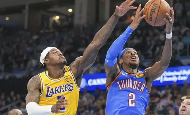 Oklahoma City Thunder guard Shai Gilgeous-Alexander, right, shoots near Los Angeles Lakers forward Jarred Vanderbilt, left, during the second half of an NBA basketball game, Tuesday, April 8, 2025, in Oklahoma City. (AP Photo/Kyle Phillips)