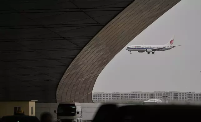 An Air China passenger jet prepares to land at the Beijing Capital International Airport Terminal 3 as gale wind alerts cancelled flights in Beijing, China, Saturday, April 12, 2025. (AP Photo/Ng Han Guan)