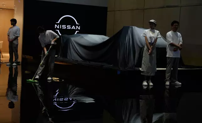 Exhibitors prepare for an unveiling at the Auto Show in Shanghai, Wednesday, April 23, 2025. (AP Photo/Ng Han Guan)
