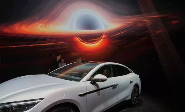 Visitors look at the Han L EV model from BYD during the Shanghai auto show on Wednesday, April 23, 2025. (AP Photo/Ng Han Guan)