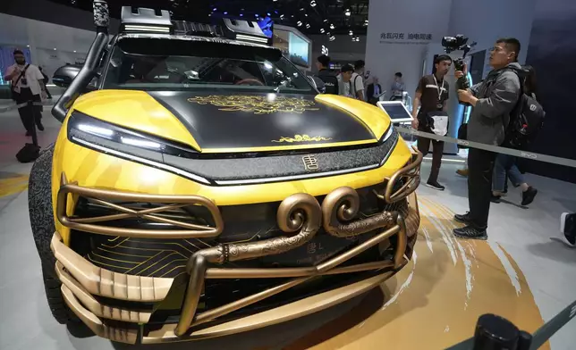 A man films near a special Black Myth:Wukong edition of a Tang L model from BYD during the Shanghai auto show on Wednesday, April 23, 2025. (AP Photo/Ng Han Guan)