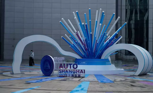 An attendee arrives to the Auto Show in Shanghai, Wednesday, April 23, 2025. (AP Photo/Ng Han Guan)