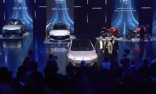 Volkswagen executives and guest pose for photos during the Volkswagen Group media night ahead of the Auto Show in Shanghai, Tuesday, April 22, 2025. (AP Photo/Ng Han Guan)