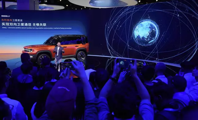 An executive from Chinese car manufacturer Geely talks the satellite communication capabilities of its Galaxy Cruiser during the Shanghai auto show on Wednesday, April 23, 2025. (AP Photo/Ng Han Guan)