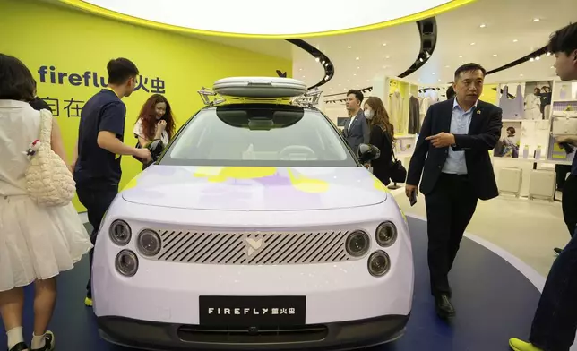 Visitors look at the new Firefly model from Chinese automaker Nio during the Shanghai auto show on Wednesday, April 23, 2025. (AP Photo/Ng Han Guan)