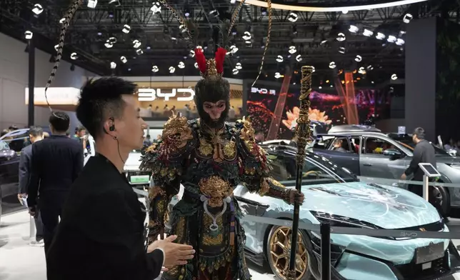 A man dressed as the character from Black Myth:Wukong promotes a special edition Han L model from BYD during the Shanghai auto show on Wednesday, April 23, 2025. (AP Photo/Ng Han Guan)