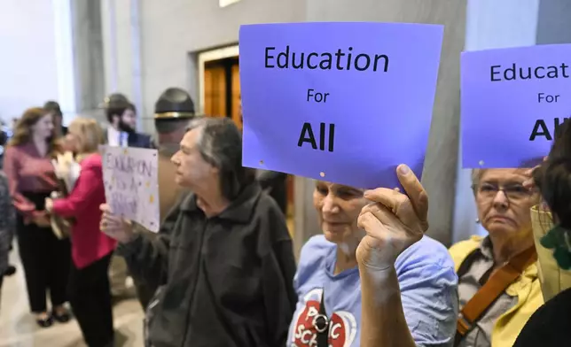 Nancy Steffen holds a sign as she protests an immigration bill outside the Senate chamber at the state Capitol Thursday, April 10, 2025 in Nashville, Tenn. (AP Photo/John Amis)