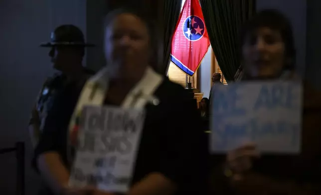 A Tennessee state flag hangs near a window of the Senate chamber as demonstrators protest an immigration bill outside at the state Capitol Thursday, in Nashville, Tenn. (AP Photo/John Amis)