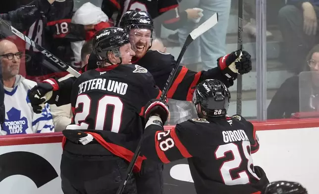 Ottawa Senators defenceman Jake Sanderson (85) celebrates his game winning goal with teammates Fabian Zetterlund (20) and Claude Giroux (28) during overtime NHL playoff action in Ottawa, on Saturday, April 26, 2025. (Adrian Wyld/The Canadian Press via AP)