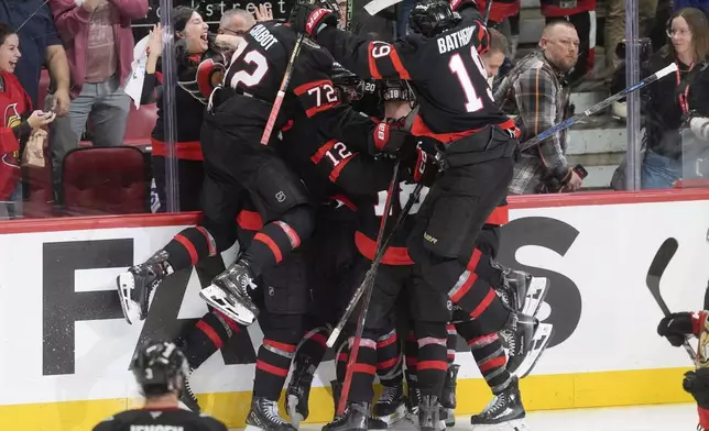 Members of the Ottawa Senators celebrate after defeating the Toronto Maple Leafs in overtime NHL playoff action in Ottawa, on Saturday, April 26, 2025. (Adrian Wyld/The Canadian Press via AP)