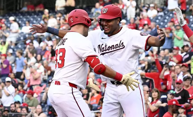 Washington Nationals' Nathaniel Lowe, left, celebrates his two-run home run with left fielder James Wood, right, during the first inning of a baseball game against the Baltimore Orioles, Tuesday, April 22, 2025, in Washington. (AP Photo/Nick Wass)