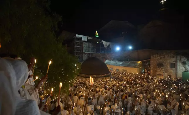 Ethiopian Orthodox Christian worshippers hold candles during the Holy Fire ceremony at the Ethiopian monks' village Deir Al-Sultan, located on the rooftop of the Church of the Holy Sepulcher, the site where according to tradition Jesus was crucified and buried, in Jerusalem's Old City, Saturday, April 19, 2025. (AP Photo/Ohad Zwigenberg)
