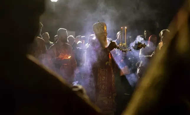Metropolitan Inokentiy, the leader of Orthodox Church in Lithuania, leads the Easter vigil Mass at the Orthodox Church of the Holy Spirit in Vilnius, Lithuania, shortly after midnight on Sunday, April 20, 2025. (AP Photo/Mindaugas Kulbis)