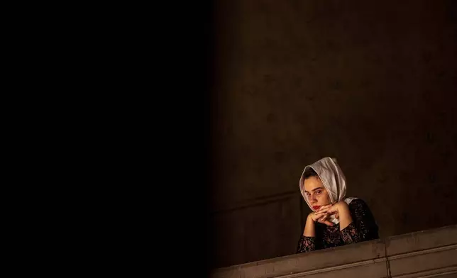 A woman attends the Orthodox Easter service at the Armenian cathedral in Bucharest, Romania, Saturday, April 19, 2025. (AP Photo/Andreea Alexandru)