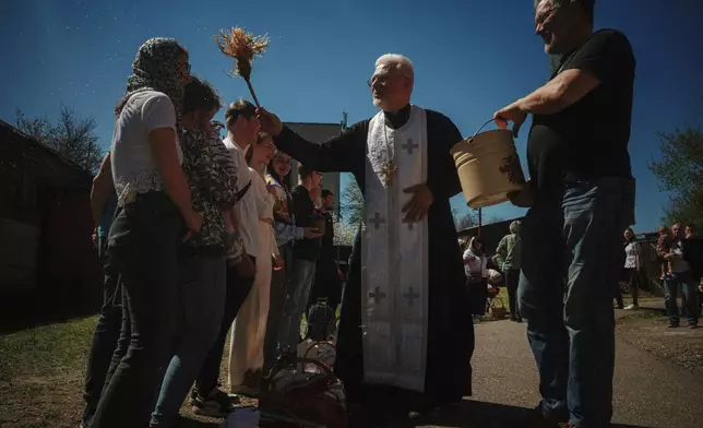 Father Henadii blesses Easter baskets during celebration of Orthodox Easter at St. John Theologian Church of the Orthodox Church of Ukraine in Kharkiv, Ukraine, on Sunday, April 20, 2025. (AP Photo/George Ivanchenko)