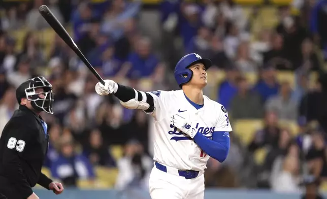 Los Angeles Dodgers' Shohei Ohtani watches his ball go out for a solo home run during the first inning of a baseball game against the Colorado Rockies Wednesday, April 16, 2025, in Los Angeles. (AP Photo/Mark J. Terrill)