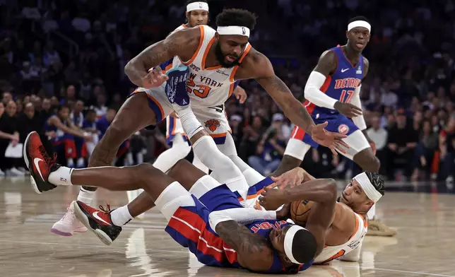 New York Knicks center Mitchell Robinson (23) and Josh Hart fight for a loose ball with Detroit Pistons forward Paul Reed during Game 5 in an NBA basketball first-round playoff series Tuesday, April 29, 2025, in New York. (AP Photo/Adam Hunger)