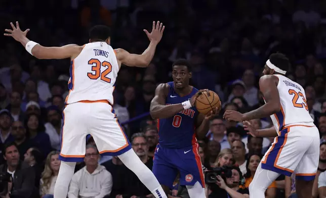Detroit Pistons center Jalen Duren (0) looks to pass around New York Knicks center Karl-Anthony Towns (32) and Mitchell Robinson (23) during Game 5 in an NBA basketball first-round playoff series Tuesday, April 29, 2025, in New York. (AP Photo/Adam Hunger)
