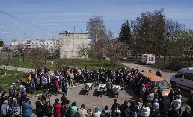 People came to say goodbye to a family of Maksym Martynenko, 11, Natalia Martynenko, 49, Mykola Martynenko, 41, which were killed in a deadly Palm Sunday Russian attack on Sumy on April 13, during farewell ceremony in Stare Selo village near Sumy, Ukraine, April 16, 2025. (AP Photo/Evgeniy Maloletka)