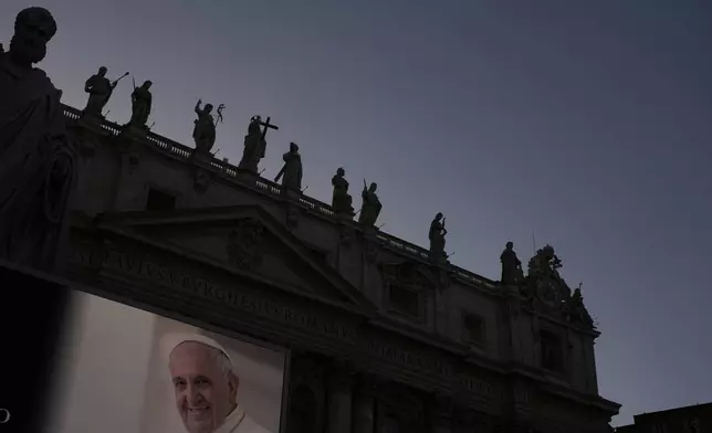 An image of Pope Francis is projected on a giant screen next to St. Peter's Basilica at the Vatican, Tuesday April 22, 2025. (AP Photo/Gregorio Borgia)