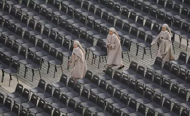 Nuns arrive to St. Peter's Square as they await the arrival of the body of Pope Francis, who will lie in state at St. Peter¥s Basilica for three days, at the Vatican, Wednesday, April 23, 2025. (AP Photo/Markus Schreiber)