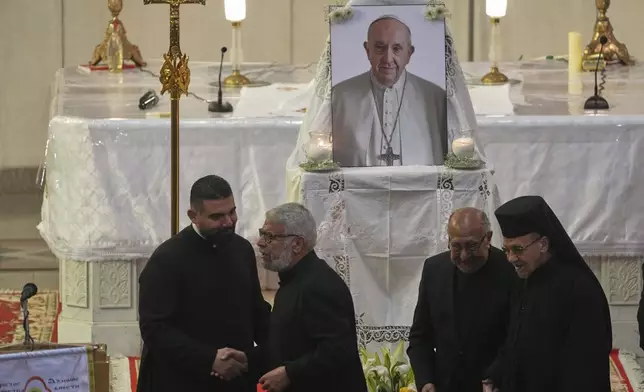 Egyptian Coptic Catholic priests share condolences after a service for late Pope Francis at the Holy Virgin Mary Coptic Catholic Cathedral in Cairo, Egypt, Tuesday, April 22, 2025. (AP Photo/Amr Nabil)