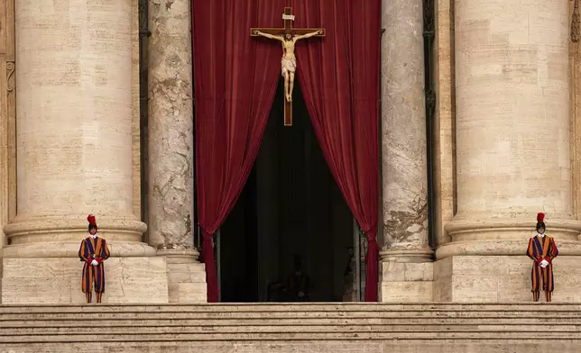 Pontifical Swiss guards stand outside the St. Peter's Basilica, in St. Peter's Square, where the body of Pope Francis will lie in state at for three days, at the Vatican, Wednesday, April 23, 2025. (AP Photo/Andreea Alexandru)