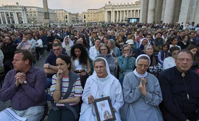 Faithful attend a rosary prayer for the late Pope Francis, in St. Peter's Square at the Vatican, Tuesday April 22, 2025. (AP Photo/Bernat Armangue)