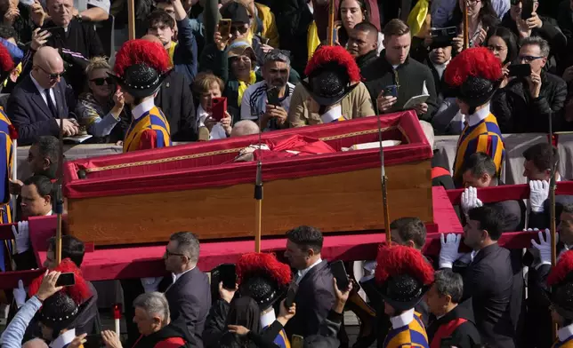The ceremony with the Pope Francis' body, who will lie in state at St. Peter's Basilica for three days, pass through the crowd at the Vatican, Wednesday, April 23, 2025. (AP Photo/Gregorio Borgia)