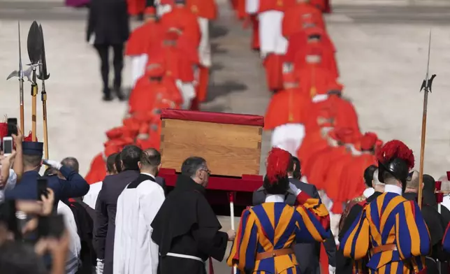 The body of Pope Francis is carried through St. Peter's Square to St. Peter's Basilica at the Vatican, Wednesday, April 23, 2025, where he will lie in state for three days. (AP Photo/Stefano Costantino)