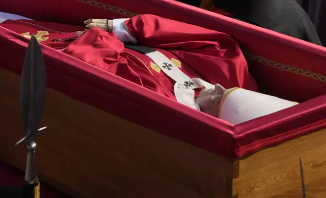 The ceremony with the Pope Francis' body, who will lie in state at St. Peter's Basilica for three days, pass through the crowd at the Vatican, Wednesday, April 23, 2025. (AP Photo/Gregorio Borgia)