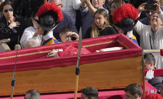 The body of Pope Francis is carried through St. Peter's Square to St. Peter's Basilica at the Vatican, Wednesday, April 23, 2025, where he will lie in state for three days. (AP Photo/Markus Schreiber)