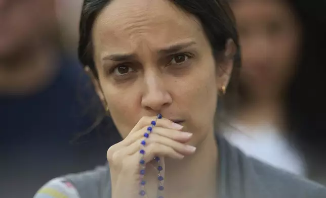 Faithful attend a rosary prayer for the late Pope Francis, in St. Peter's Square at the Vatican, Tuesday April 22, 2025. (AP Photo/Bernat Armangue)