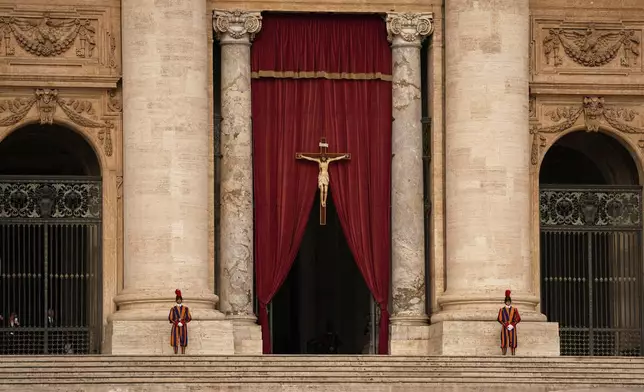 Pontifical Swiss guards stand outside the St. Peter's Basilica, in St. Peter's Square, where the body of Pope Francis will lie in state at for three days, at the Vatican, Wednesday, April 23, 2025. (AP Photo/Andreea Alexandru)