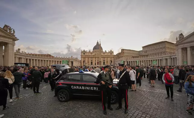 People wait in St. Peter's Square to pay their respects to the late Pope Francis, who will lie in state at St. Peter's Basilica for three days, at the Vatican, Wednesday, April 23, 2025. (AP Photo/Andreea Alexandru)