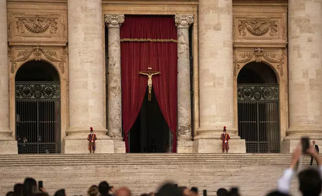 People gather in St. Peter's Square as they await the arrival of the body of Pope Francis, who will lie in state at St. Peter's Basilica for three days, at the Vatican, Wednesday, April 23, 2025. (AP Photo/Andreea Alexandru)