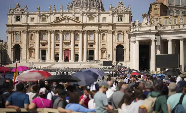 People queue in St. Peter's Square to pay their respect to the late Pope Francis, who will lie in state at St. Peter's Basilica for three days, at the Vatican, Wednesday, April 23, 2025. (AP Photo/Francisco Seco)