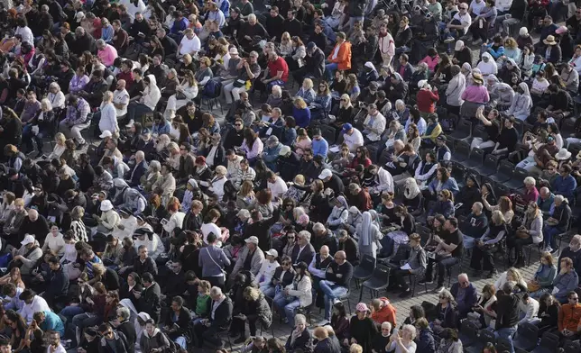 People gather in St. Peter's Square as they await the arrival of the body of Pope Francis, who will lie in state at St. Peter¥s Basilica for three days, at the Vatican, Wednesday, April 23, 2025. (AP Photo/Markus Schreiber)