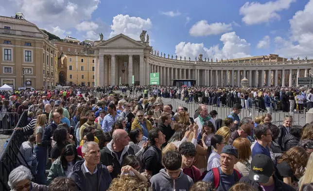 People wait in line to enter St. Peter's Basilica where Pope Francis is lying in state, at the Vatican, Friday, April 25, 2025. (AP Photo/Bernat Armangue)