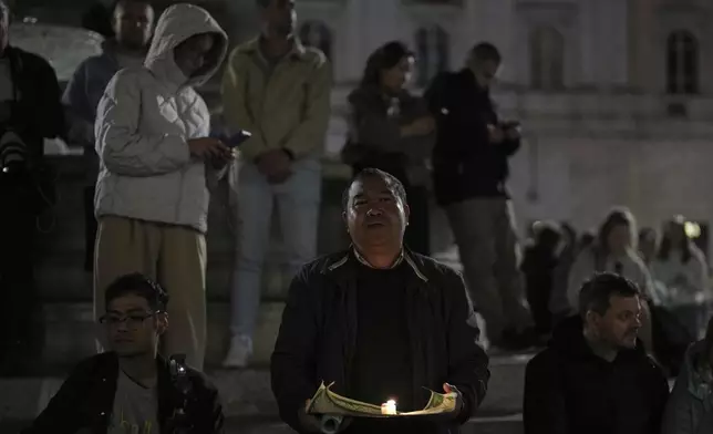 Faithful pray the rosary outside St. Mary Major Basilica, in Rome, Friday, April 25, 2025. (AP Photo/Francisco Seco)