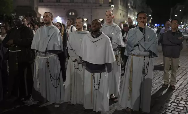 Priests and faithful pray the rosary outside St. Mary Major Basilica, in Rome, Friday, April 25, 2025 (AP Photo/Francisco Seco)