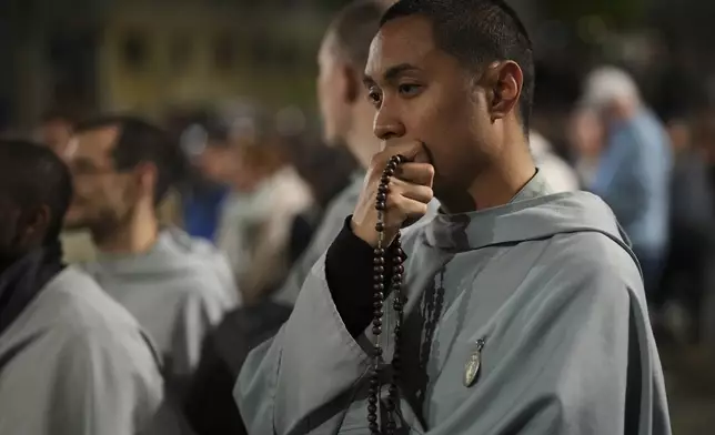 Faithful pray the rosary outside St. Mary Major Basilica, in Rome, Friday, April 25, 2025 (AP Photo/Francisco Seco)
