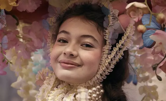 A reveler wearing decorated hat and costume pause for a portrait as she participates in the annual Easter Parade and Bonnet Festival in front of St. Patrick's Cathedral on Sunday, April 20, 2025, in New York. (AP Photo/Andres Kudacki)