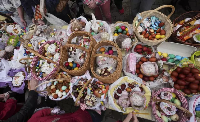 Believers with their baskets containing traditional cakes and painted eggs wait to be blessed by an Orthodox priest, in preparation for an Easter celebration at a church in Tallinn, Estonia, Saturday, April 19, 2025. (AP Photo/Sergei Grits)