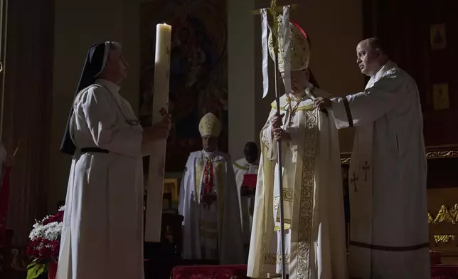 Louis Sako, center, patriarch of Iraq's Chaldean Catholic Church blesses the faithful during attend Easter religious services at Mar Youssif Chaldean Church in Baghdad, Iraq, Saturday, April 19, 2023. (AP Photo/Hadi Mizban)