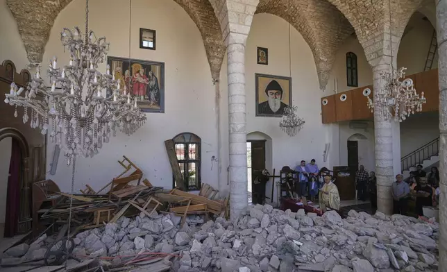 Worshippers gather for Easter Mass inside the ruins of St. George Melkite Catholic Church in Dardghaya, southern Lebanon, Sunday, April 20, 2025, after the church was heavily damaged in an Israeli airstrike earlier in the conflict. (AP Photo/Hassan Ammar)